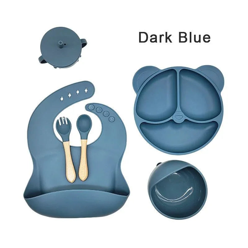 Dark blue silicone baby feeding set with lid, bowl, and utensils on a white background.