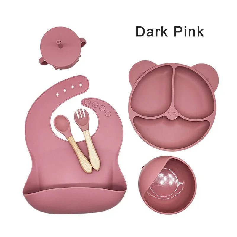 Dark pink children's dining set with lid, bowl, and utensils on a white background.