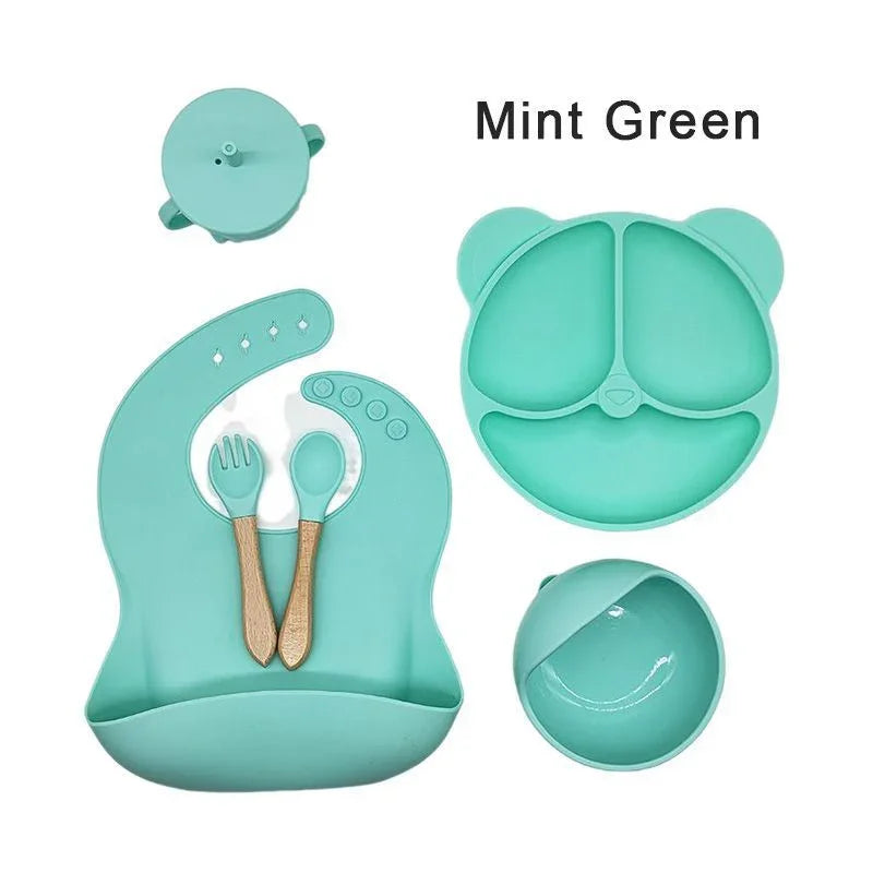 Mint green baby utensil set with lid on a white background